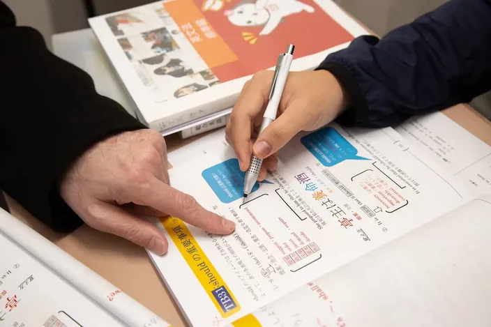 参考書を指しながら1対1で疑問を解消する様子