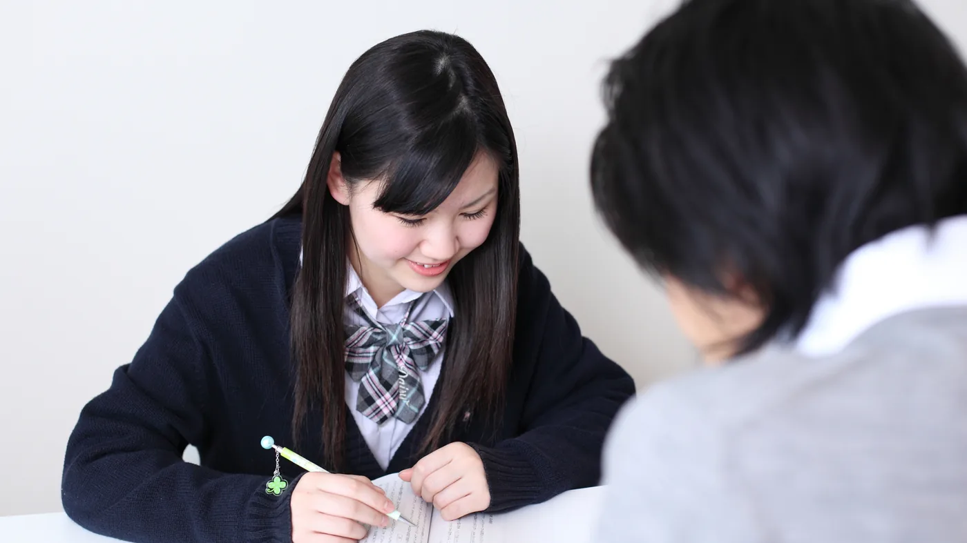 中高一貫校に通う中学生が、先生と1対1で問題を解いている様子