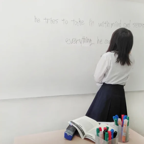生徒がホワイトボードで先生に授業をする様子