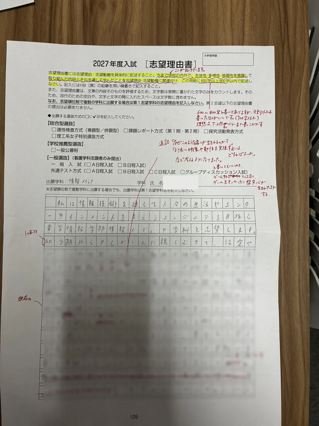 志望理由書の実物用紙。担当講師が赤ペンで文章表現や構成への指摘を余白に書き込んでいる