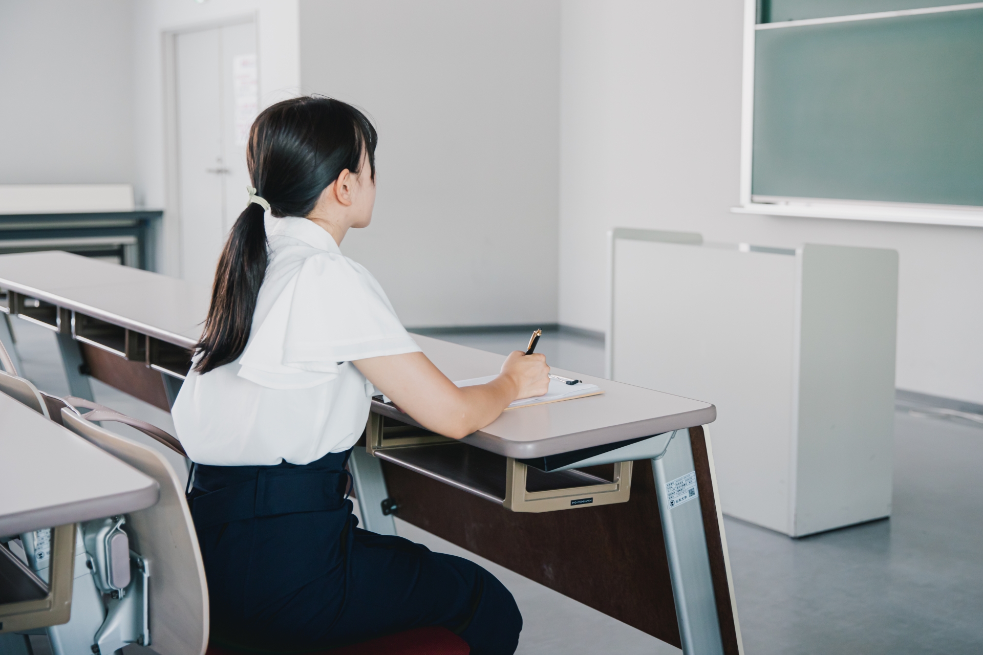 教室で授業を受ける学生　女性　勉強　黒板