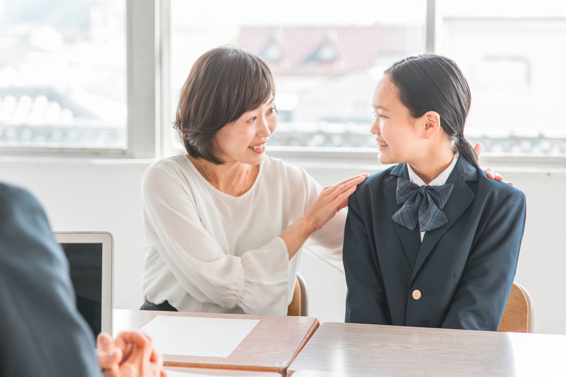 笑顔で三者面談を受ける親子と先生