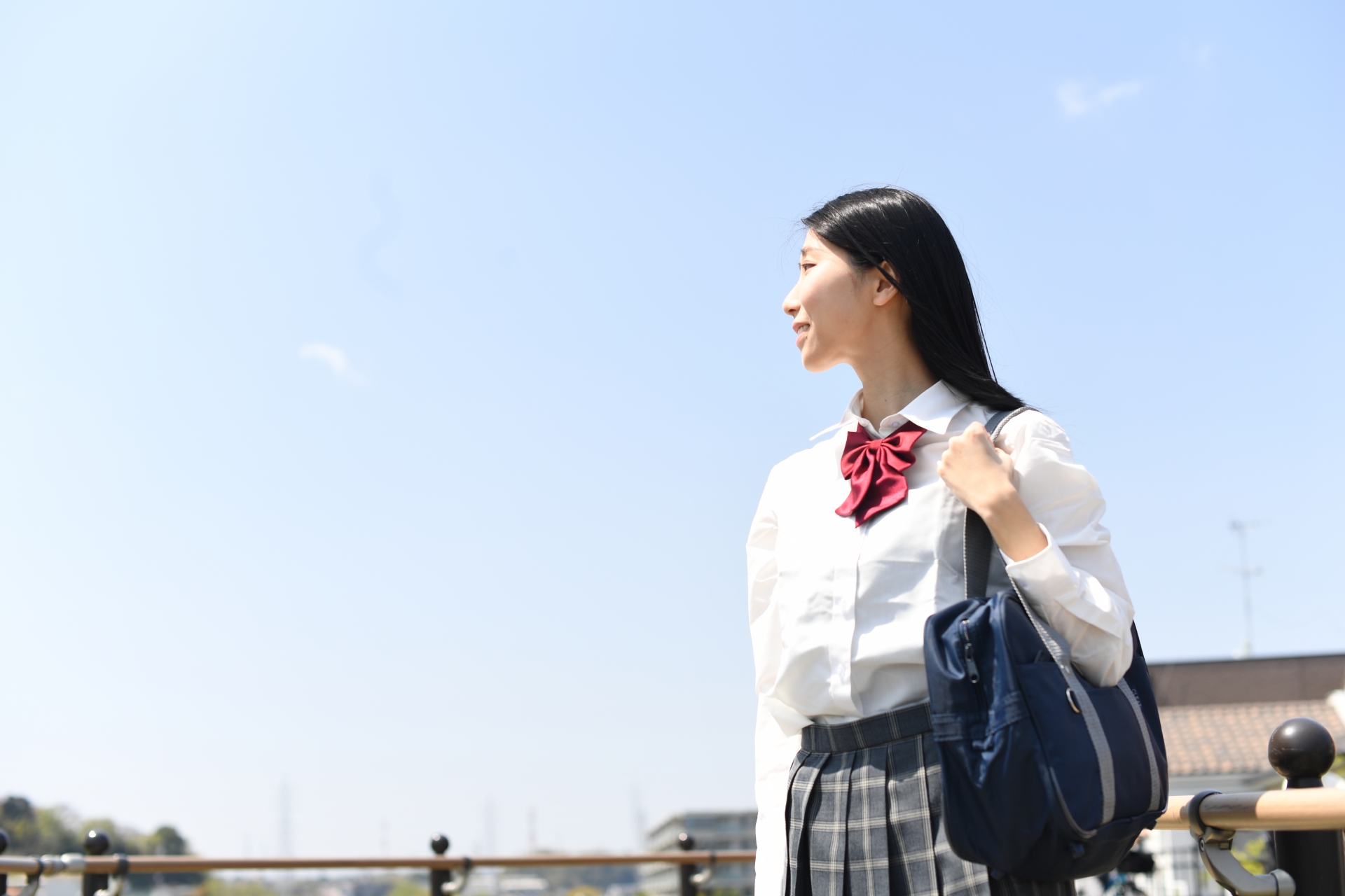 青空と黒髪の女子学生のイメージ