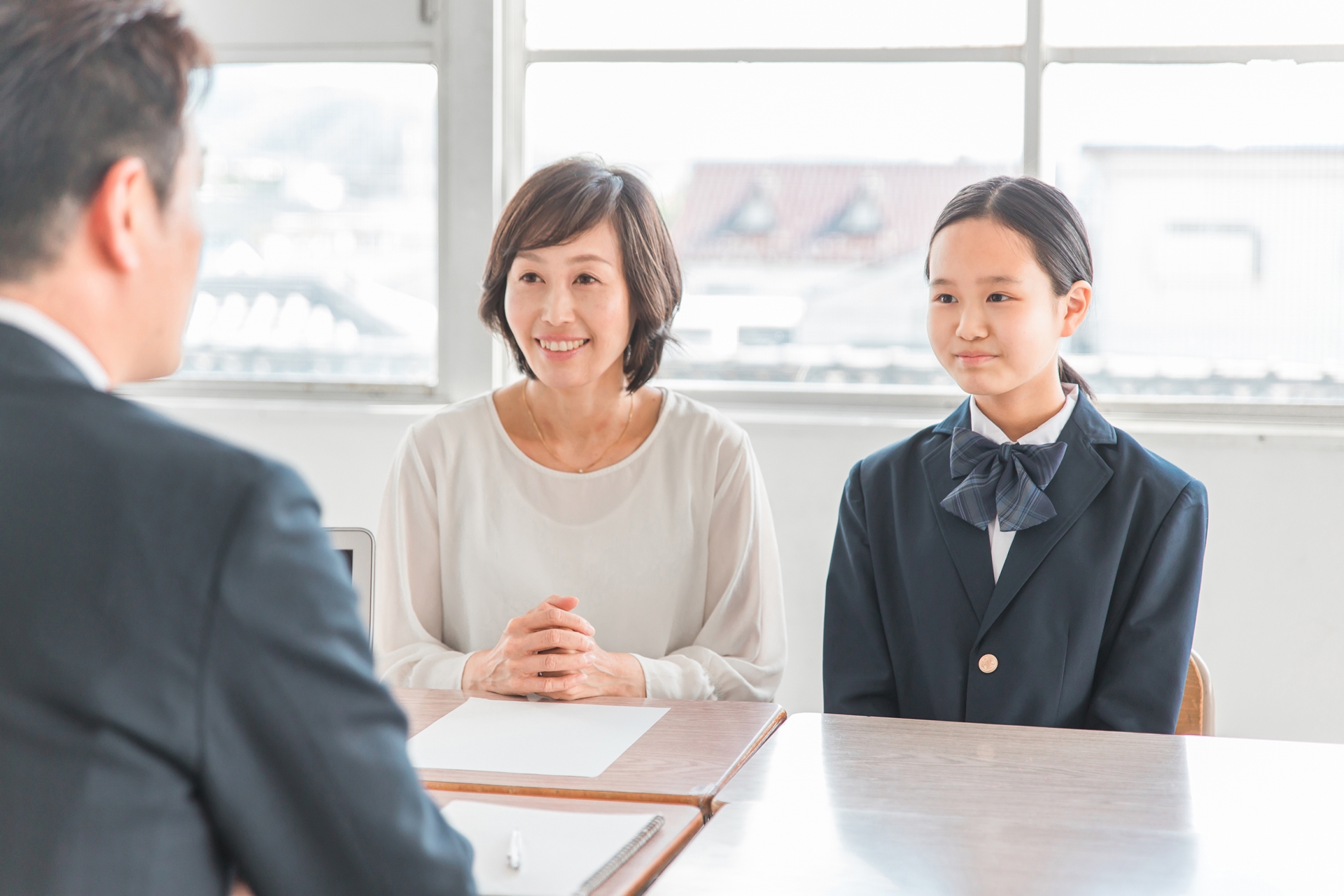 笑顔で三者面談を受ける親子と先生