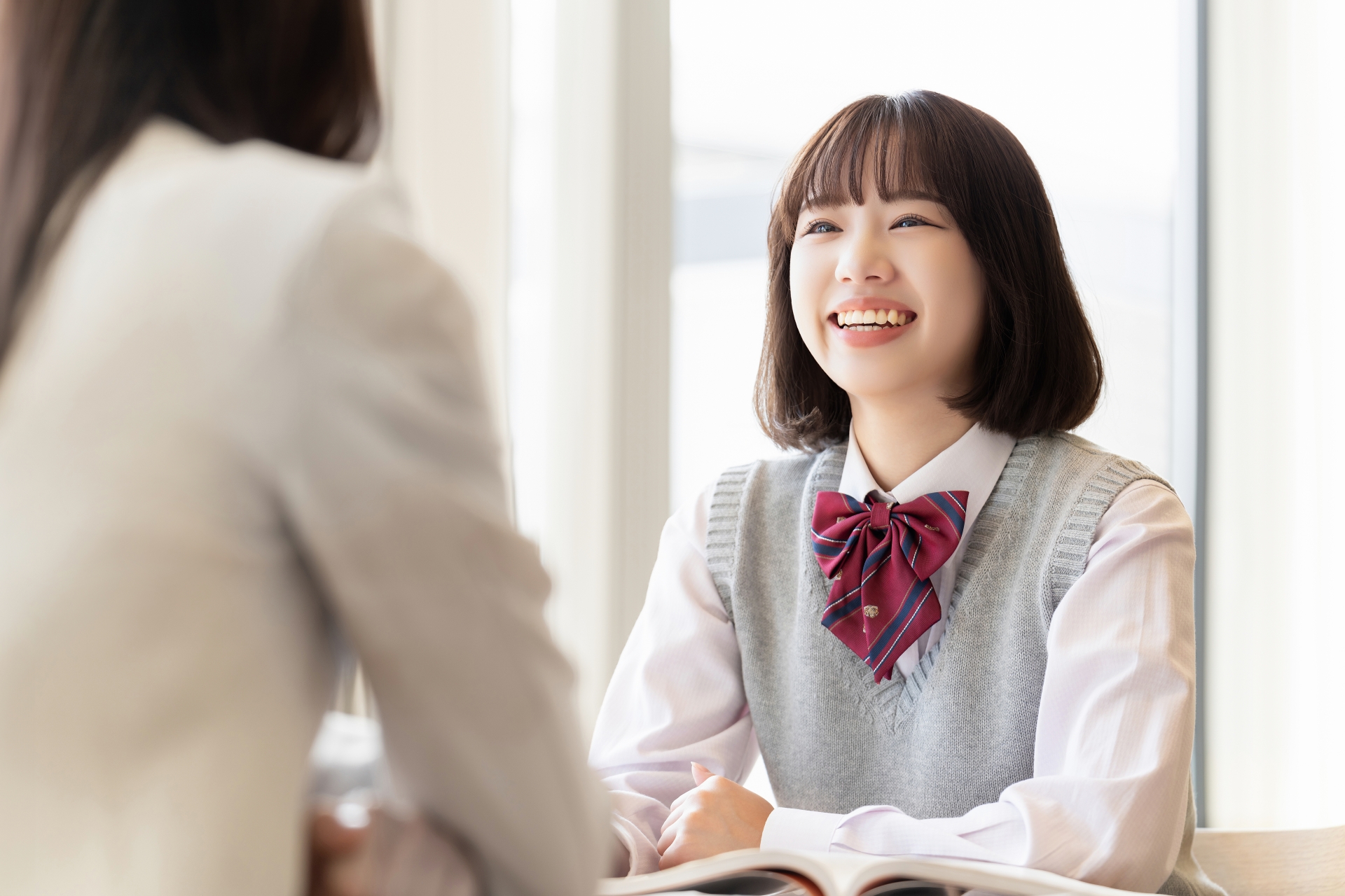 先生と話す女子学生