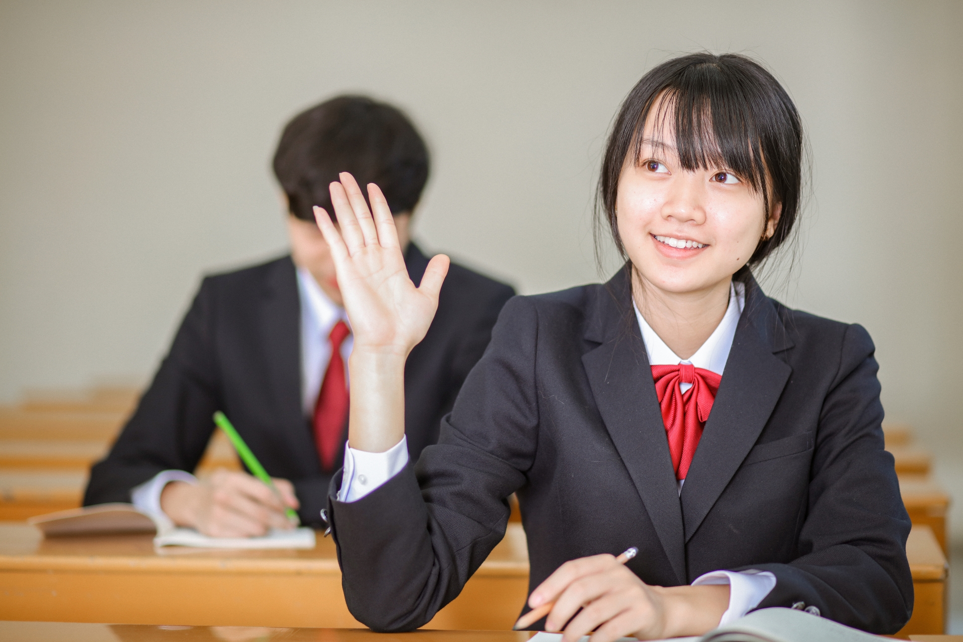 手をあげる女子学生