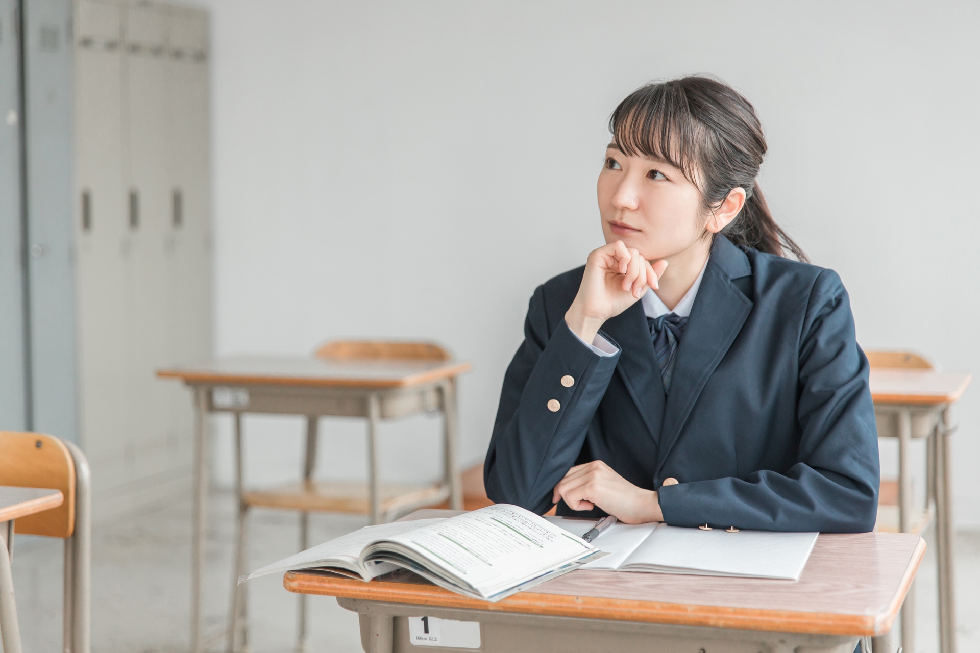 授業で教科書を見ながら勉強する女子高校生