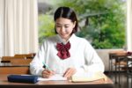 授業中に勉強をする女子学生のイメージ