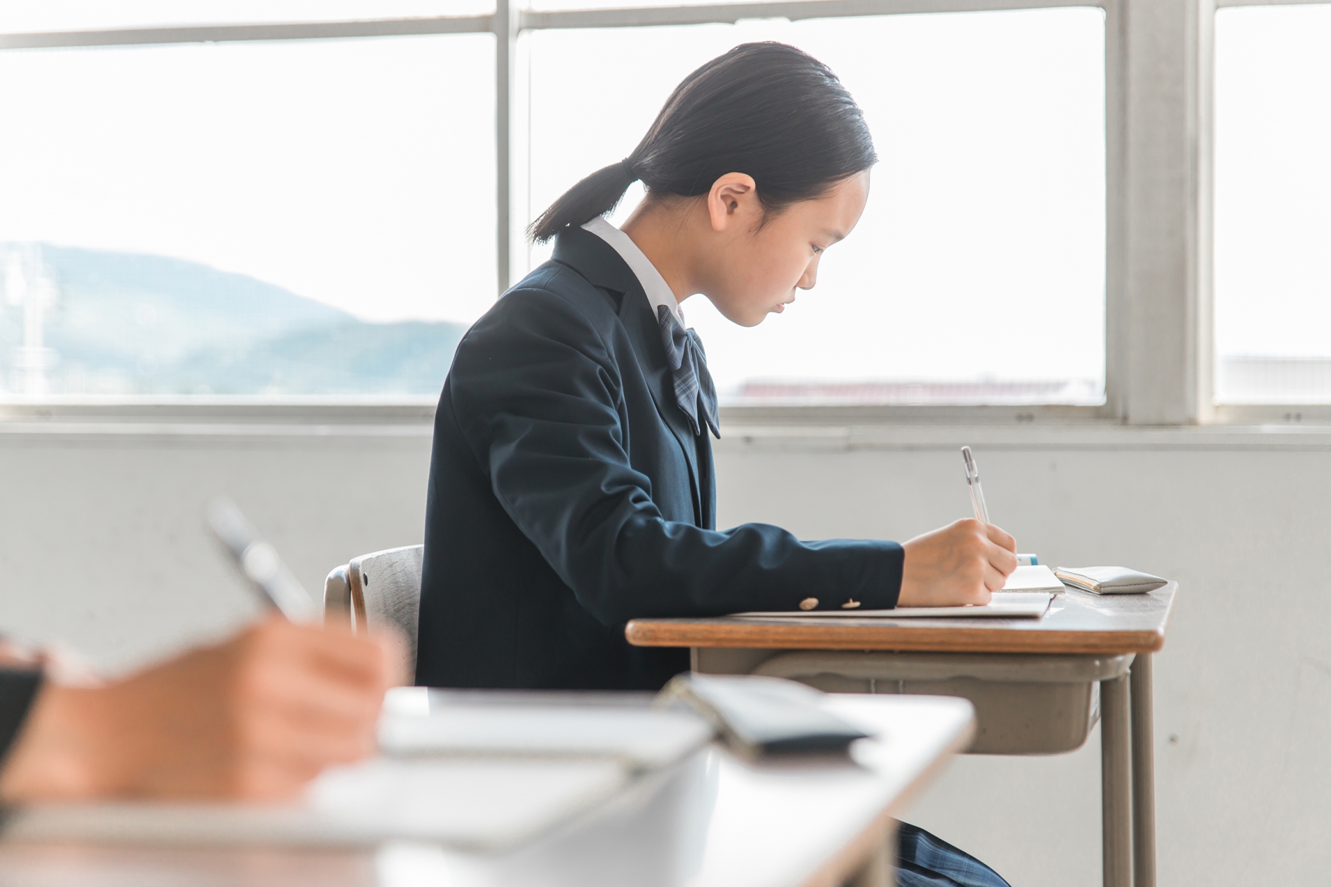 机に向かう女子学生