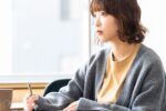 真剣な表情でメモを取る女性