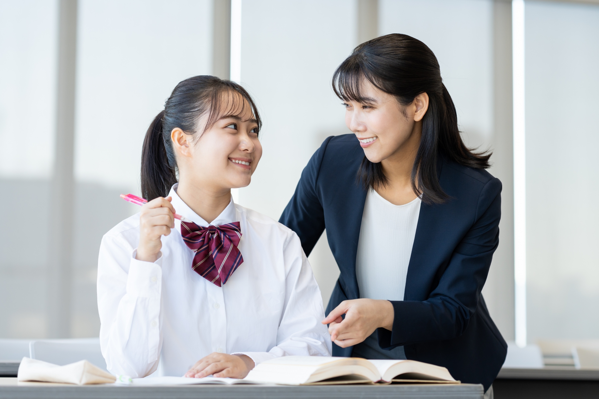 塾で勉強する高校生と先生