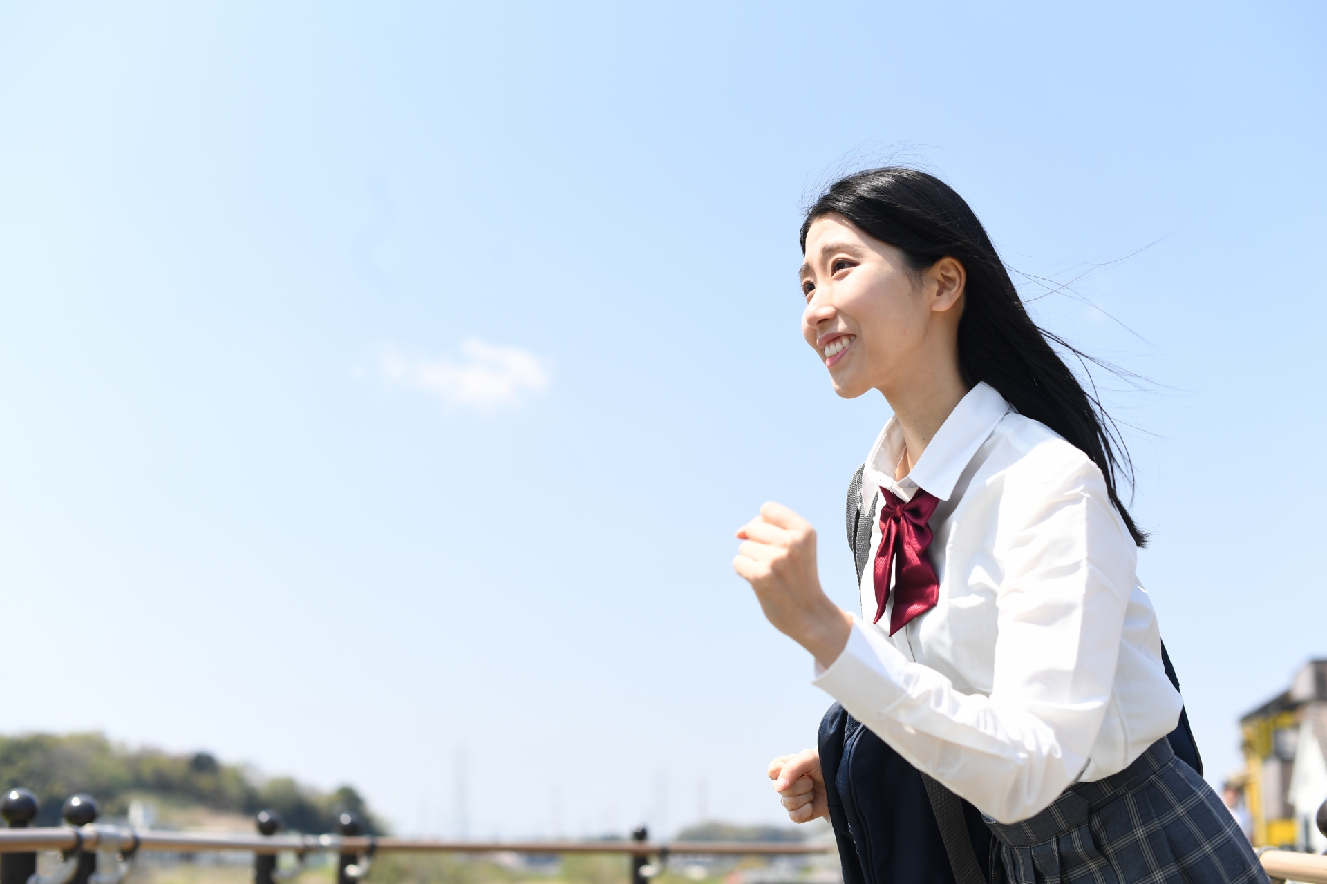 青空の下で走る女子学生