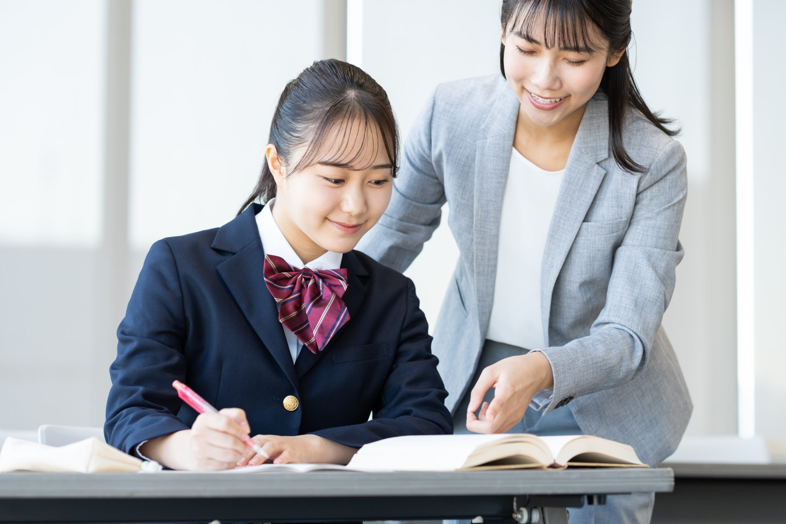 塾で勉強する女子高生と講師