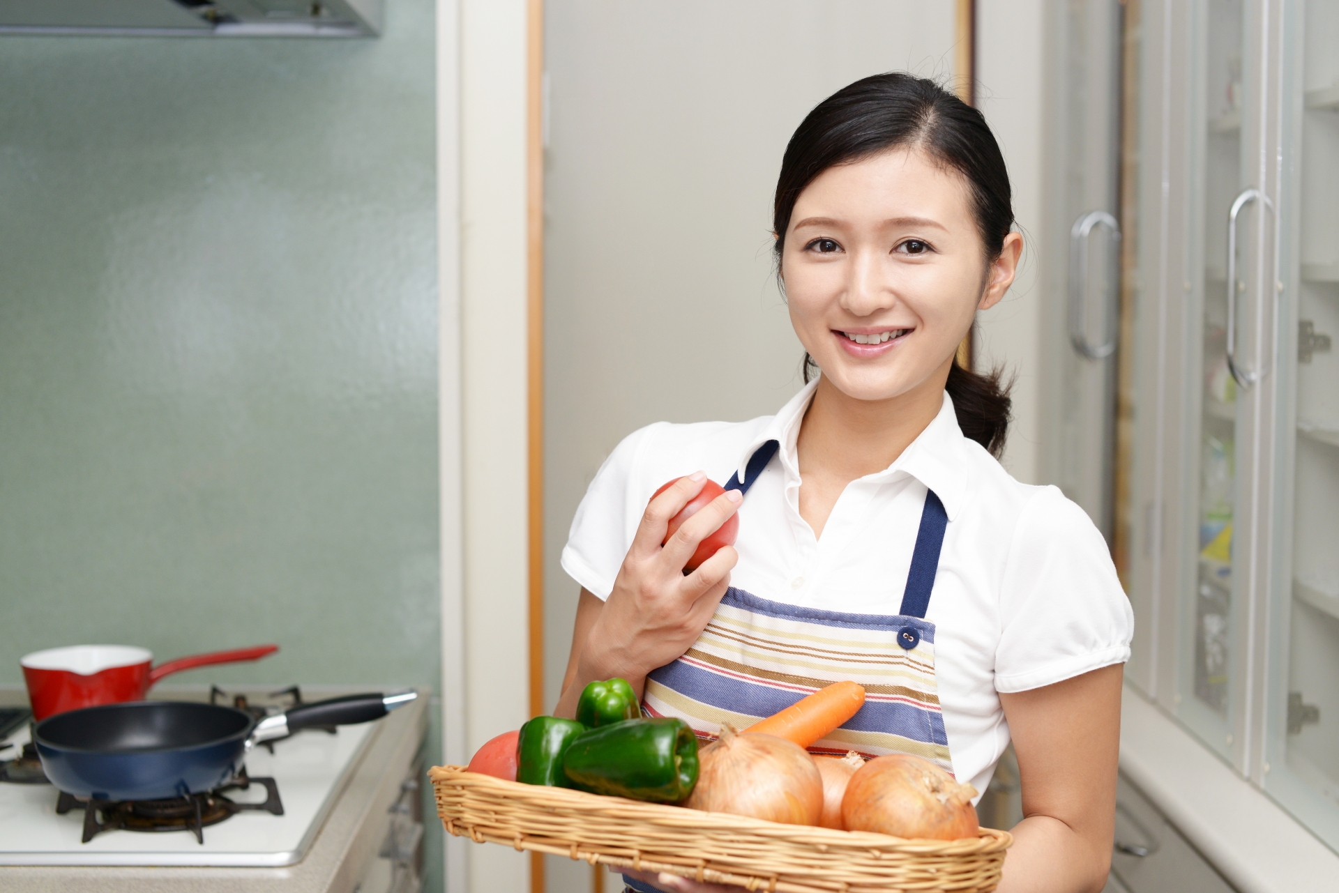 野菜を持つ笑顔の女性
