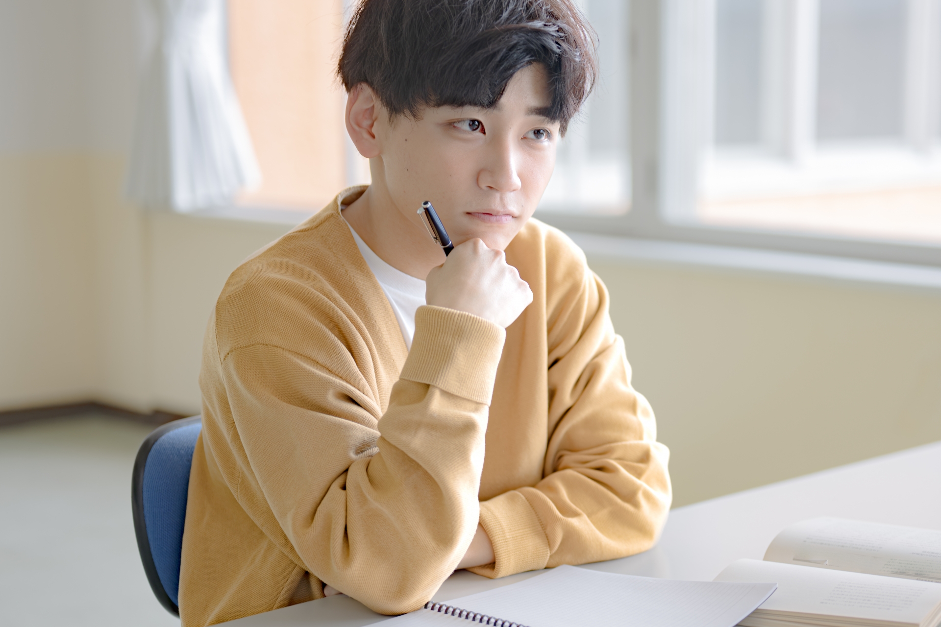 悩む勉強中の私服男性