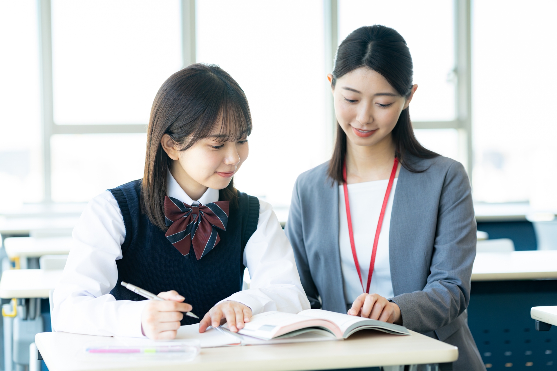勉強する女子学生と先生