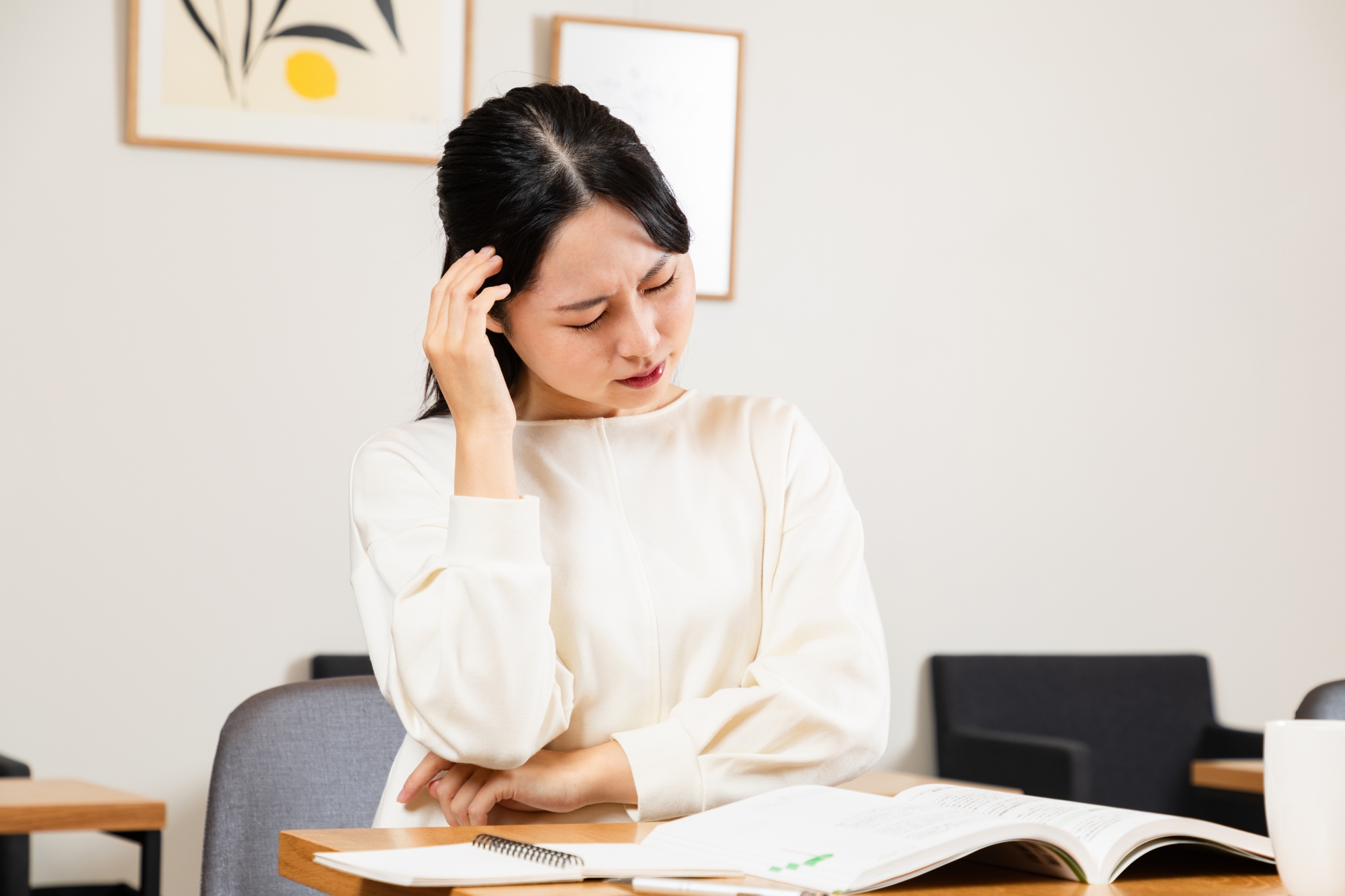 勉強中に頭痛がする女性