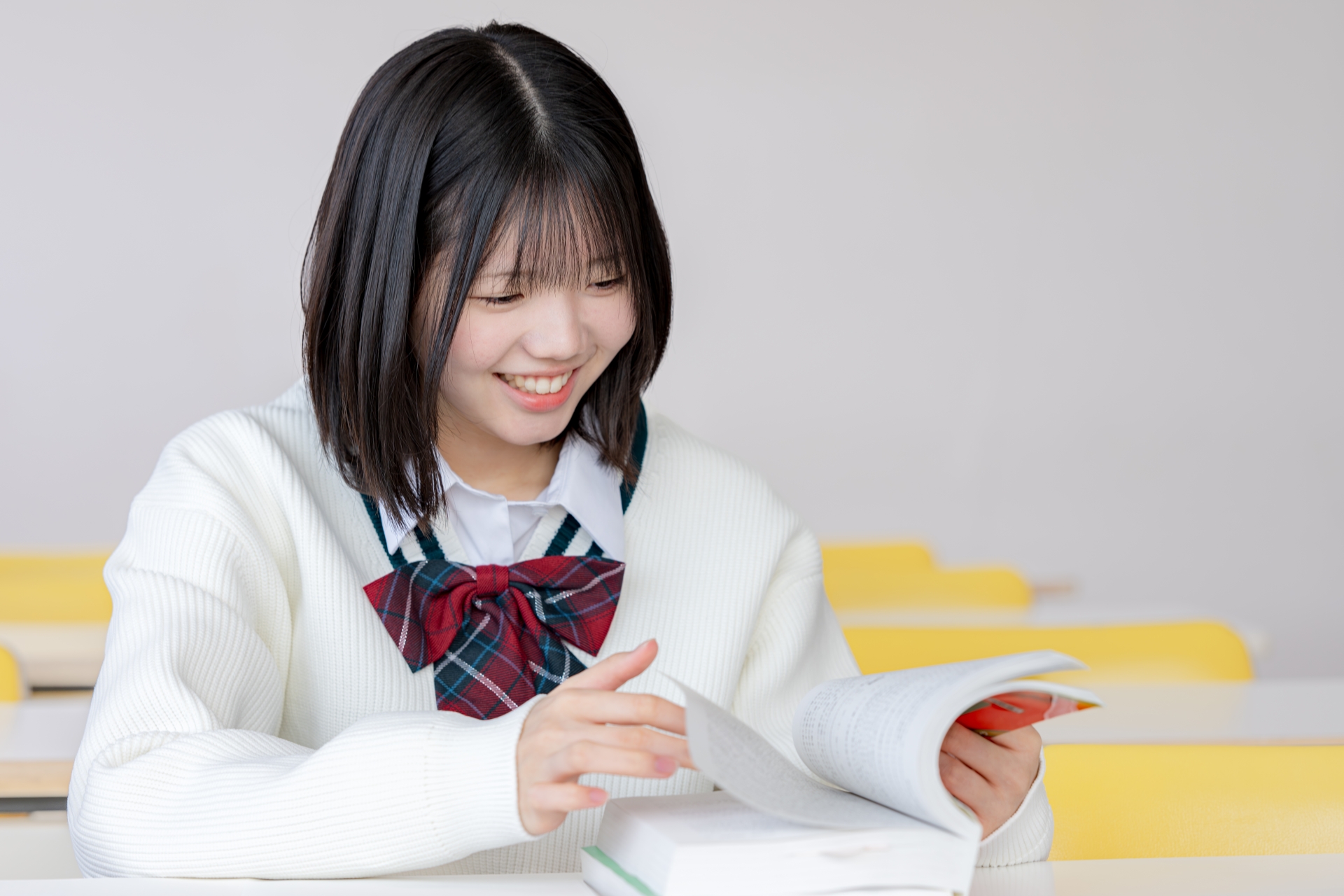 笑顔で教材を見る女子生徒