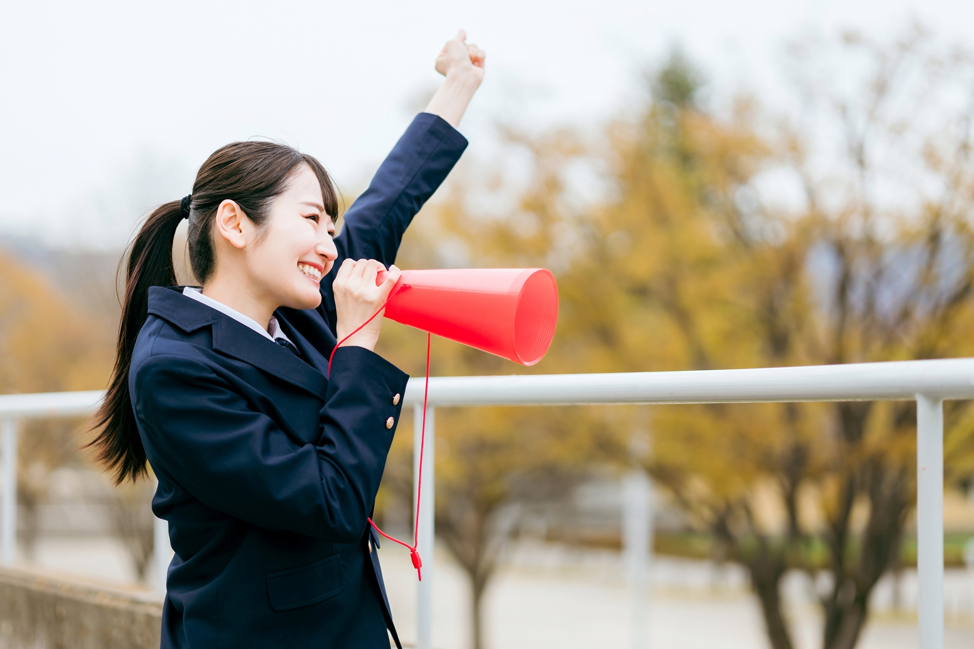 メガホンを使って声援を送る女子高校生