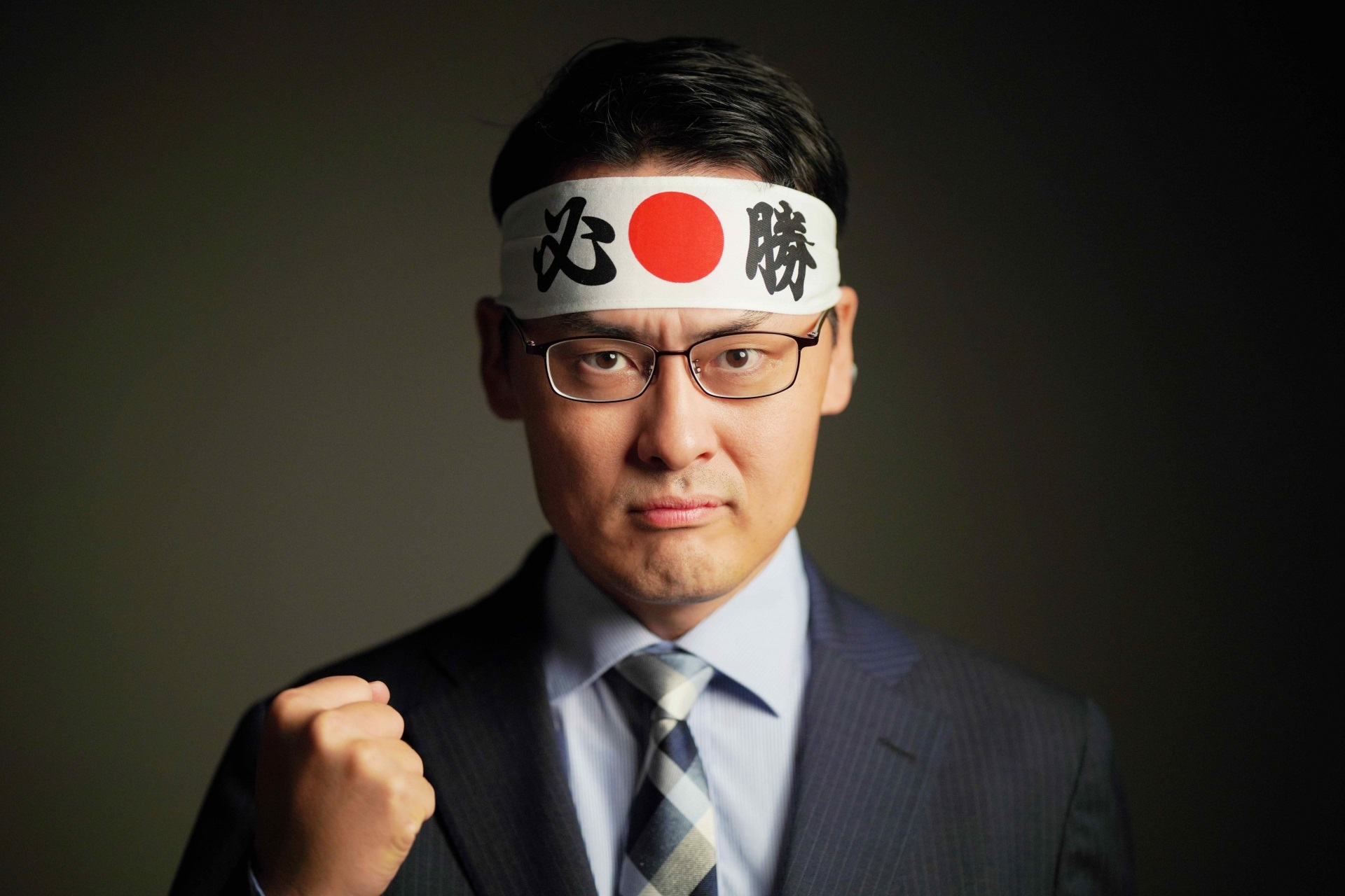 必勝鉢巻きをつけるスーツの男性