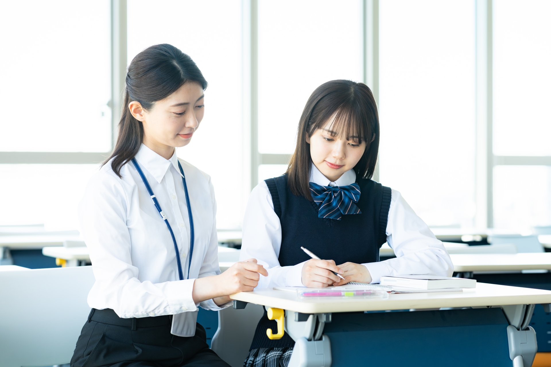 勉強する女子学生と先生