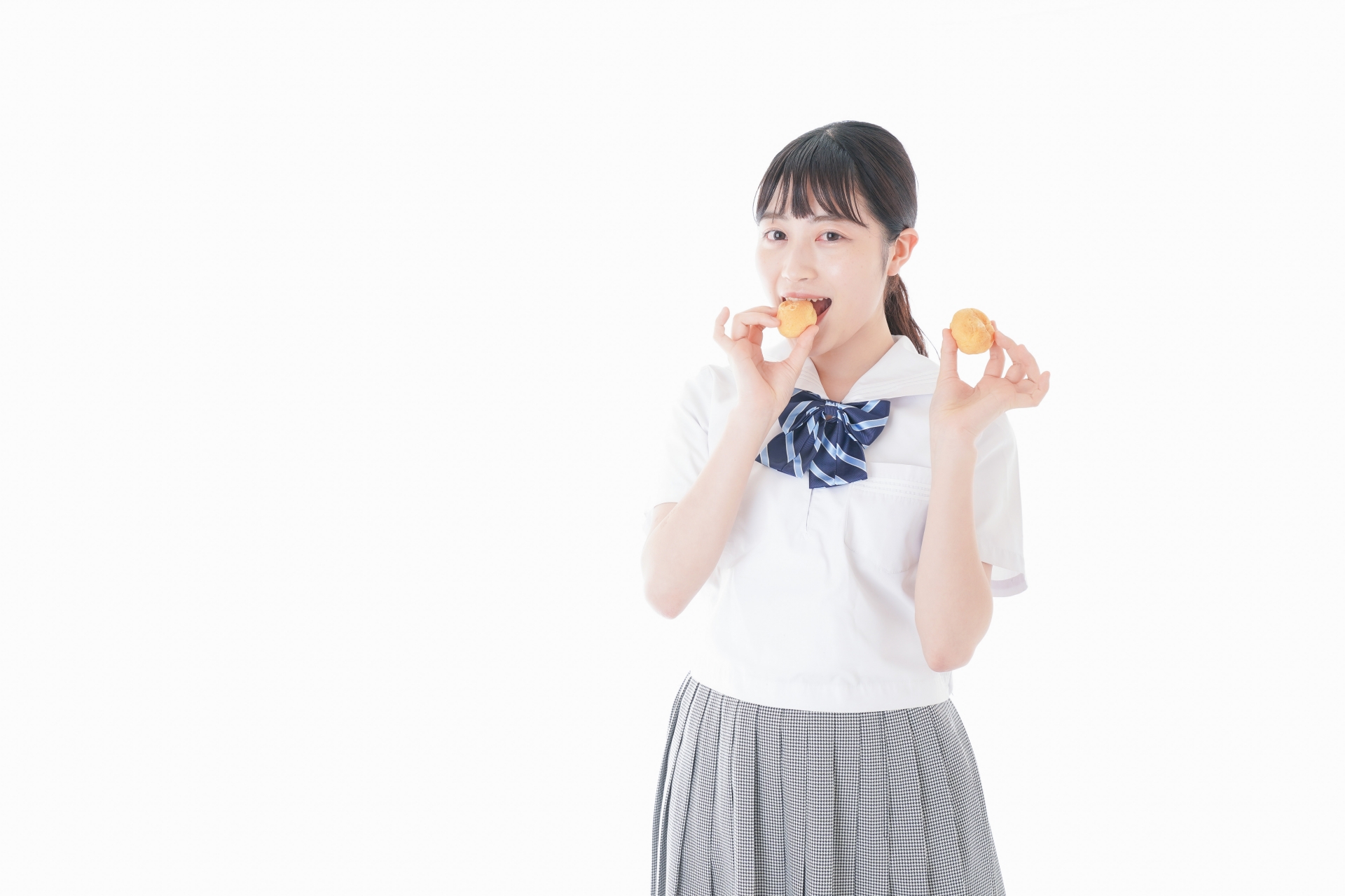 おやつを食べる制服姿の女子学生
