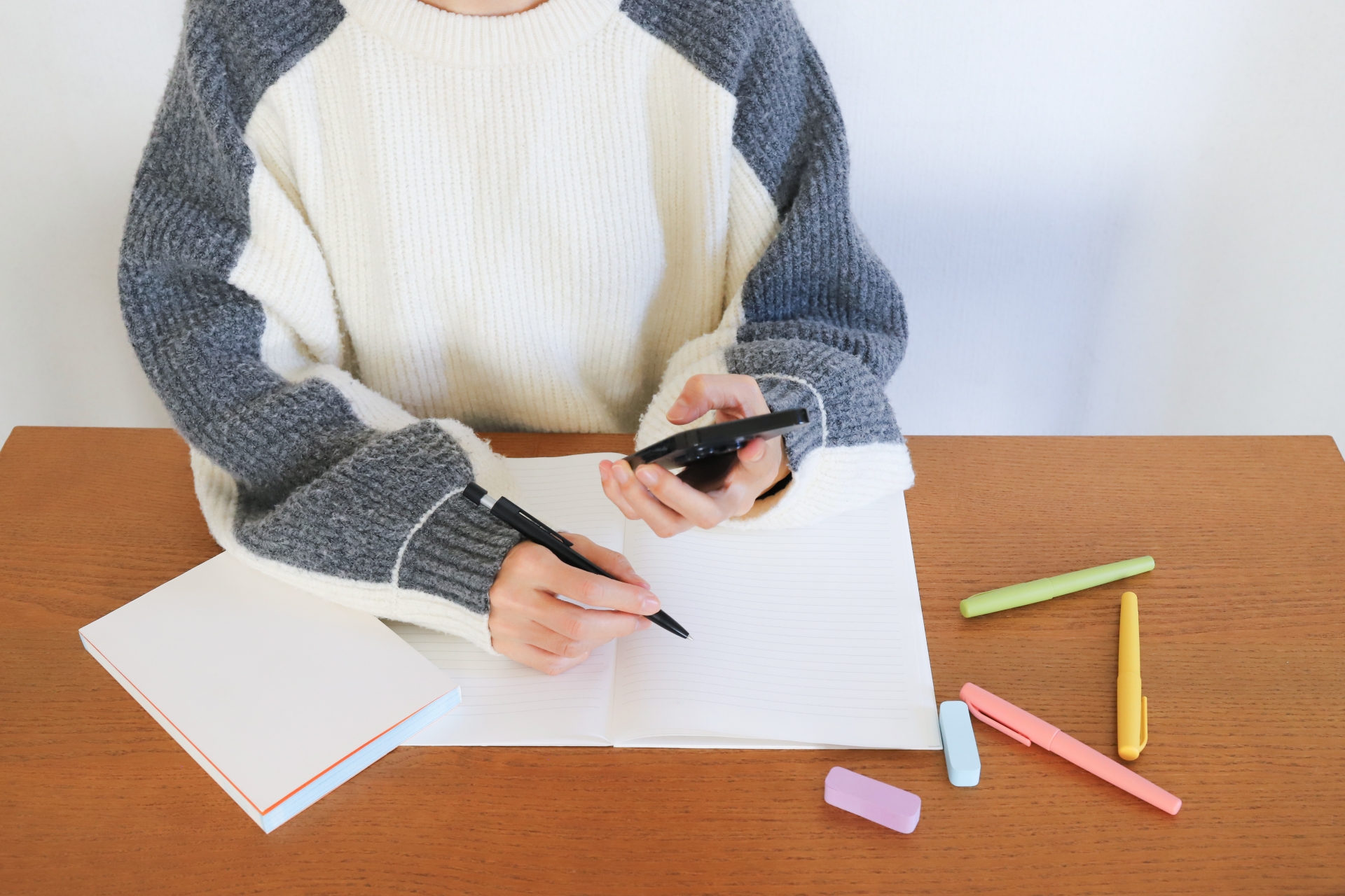 スマホを見ながら勉強する学生
