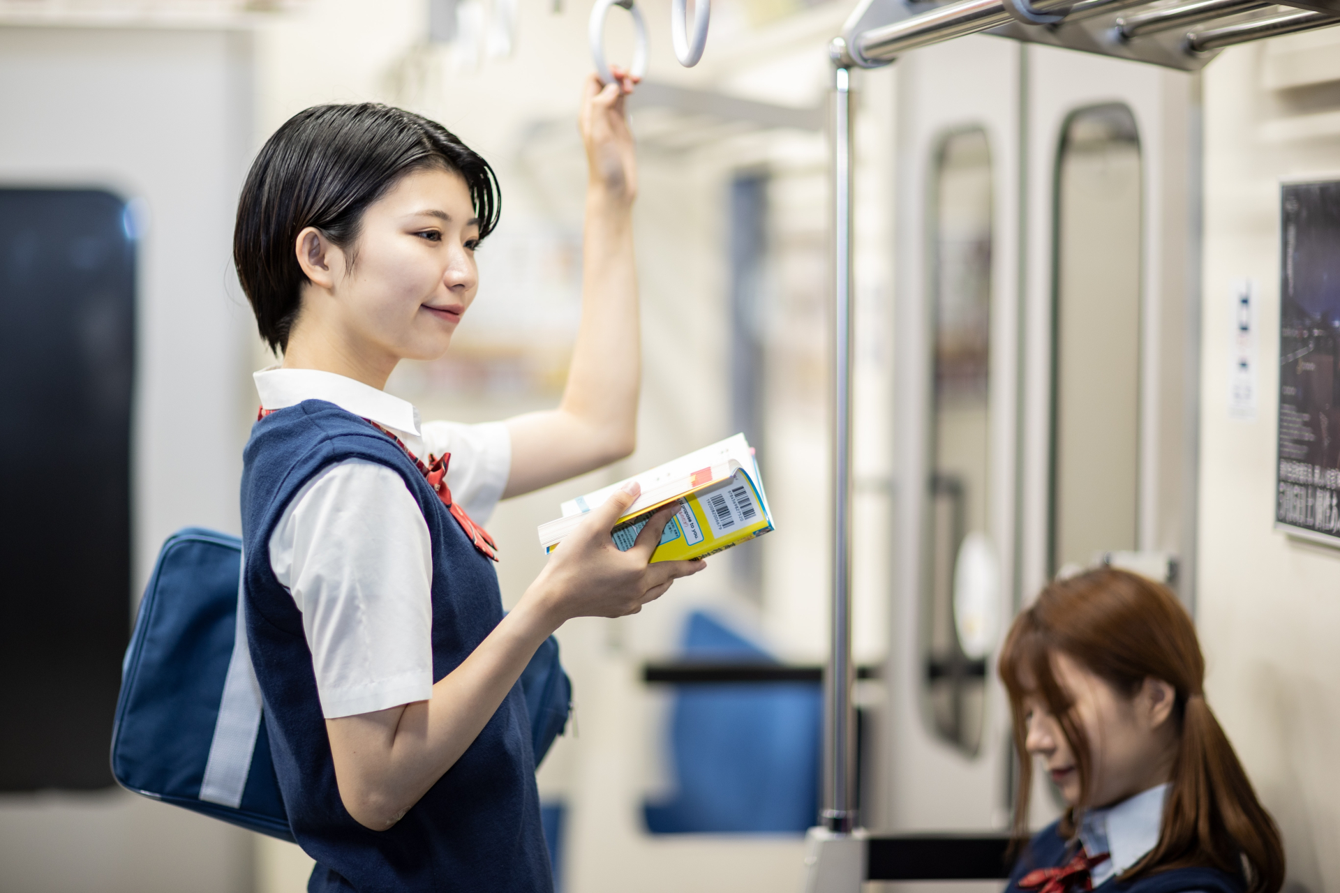 参考書を持って遠くを見ている高校生