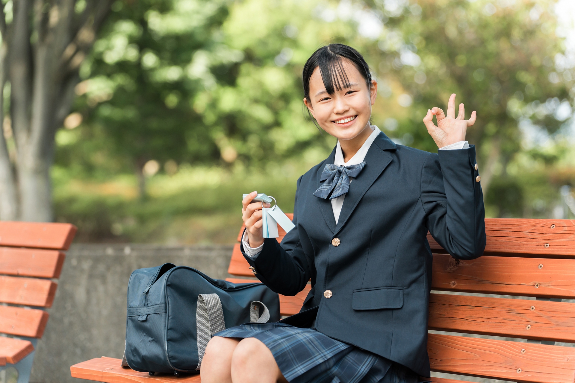 単語帳を使って勉強する中学生・女子高生