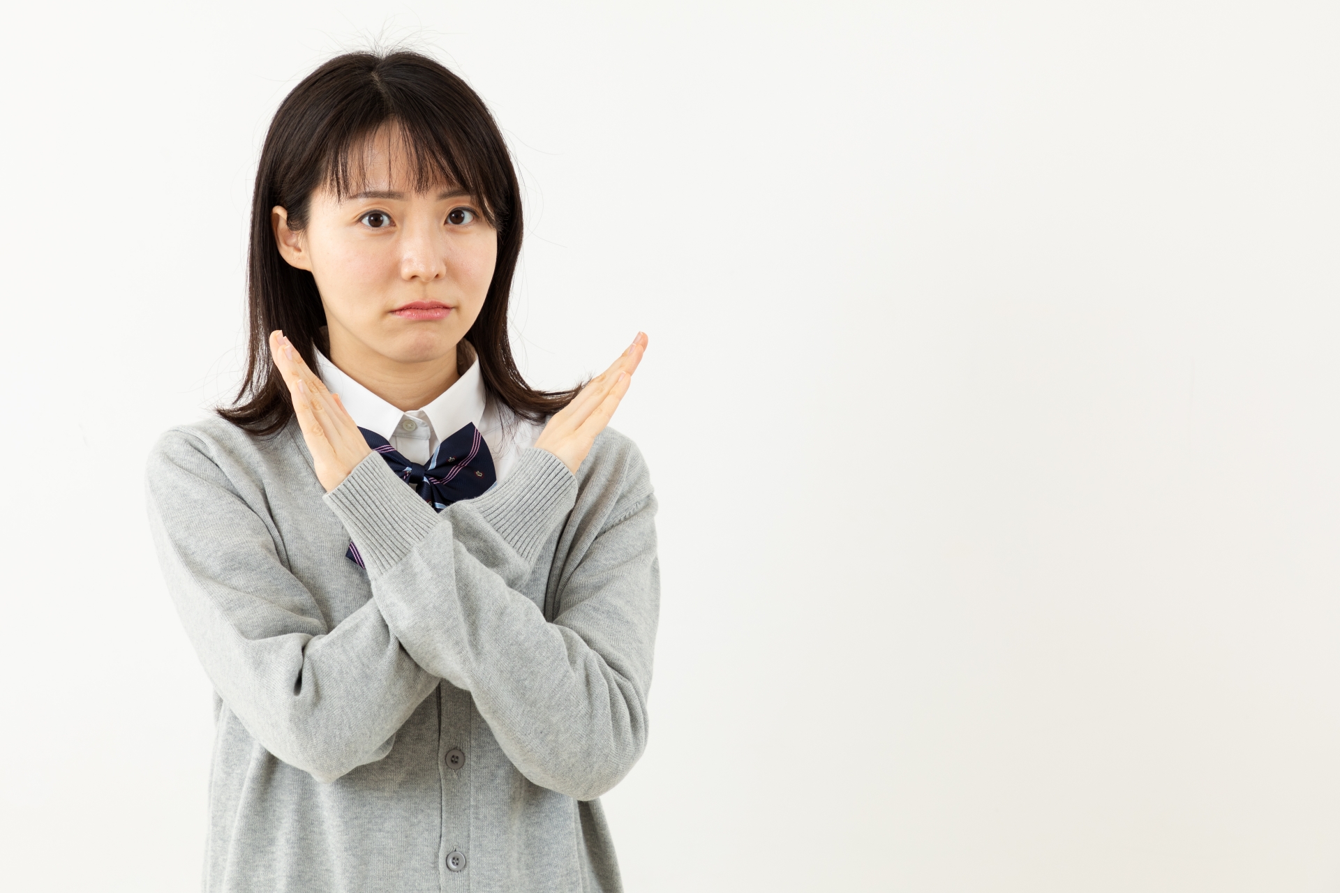 バツ印を出すアジア人女子高生
