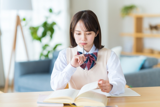 自宅で勉強中に悩む女子高生