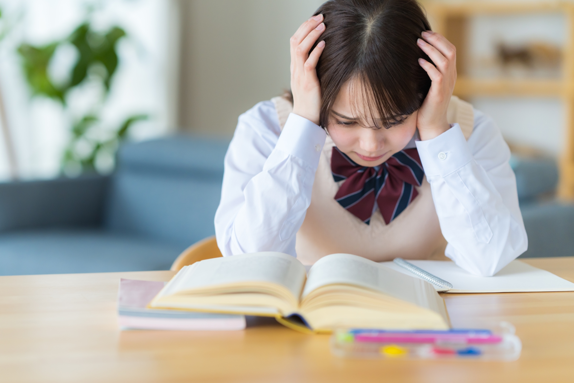 自宅で勉強中に悩む女子高生