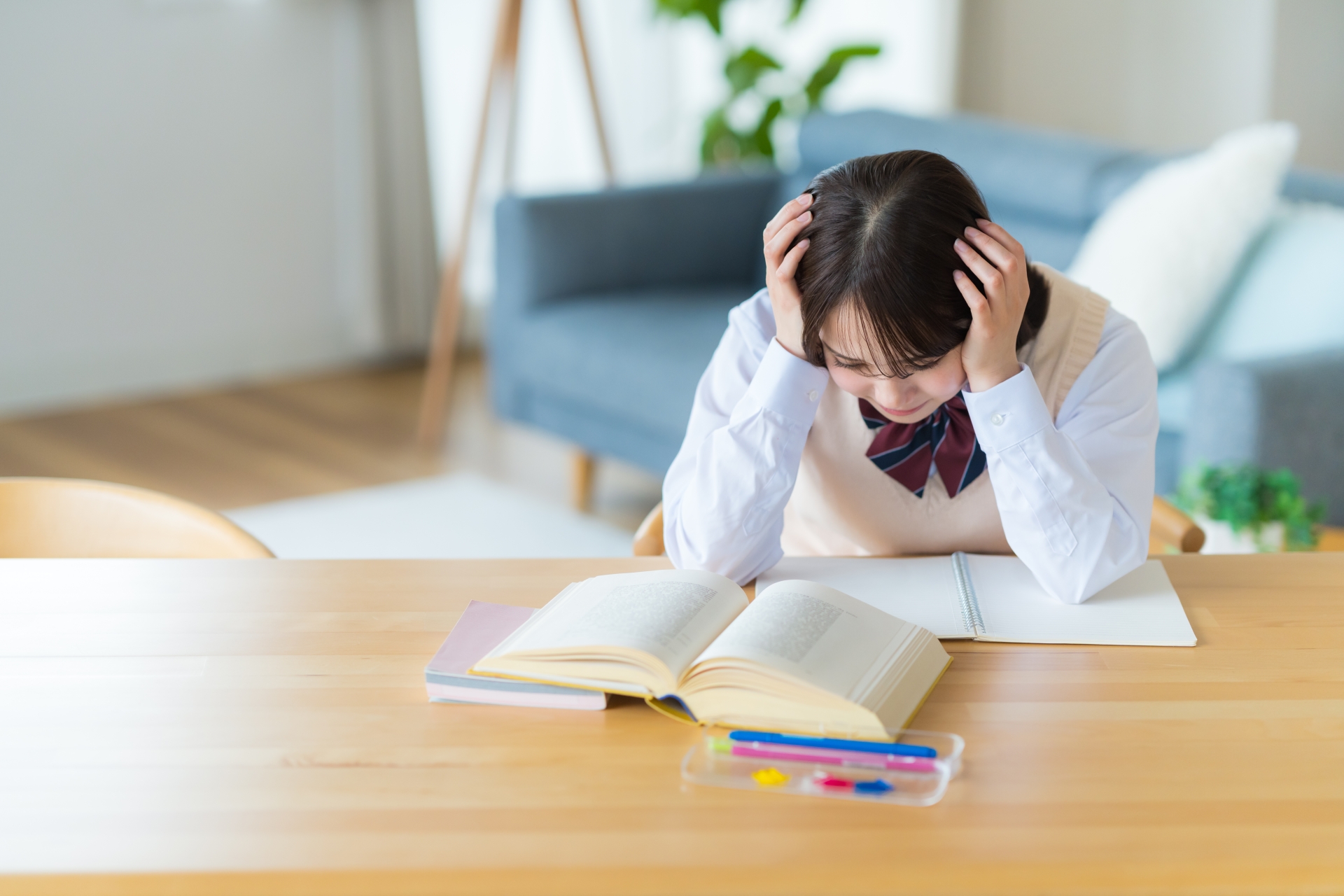 自宅で勉強中に悩む女子高生