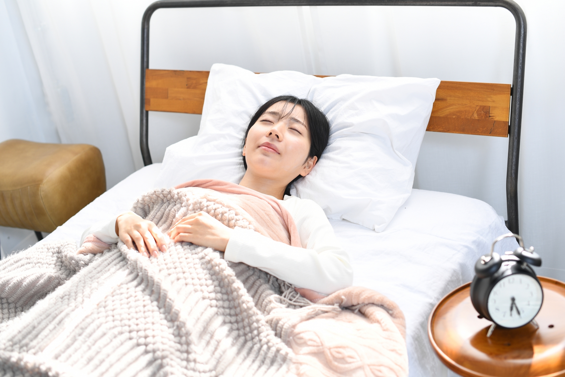 心地良くベッドで寝るアジア人の若い女性