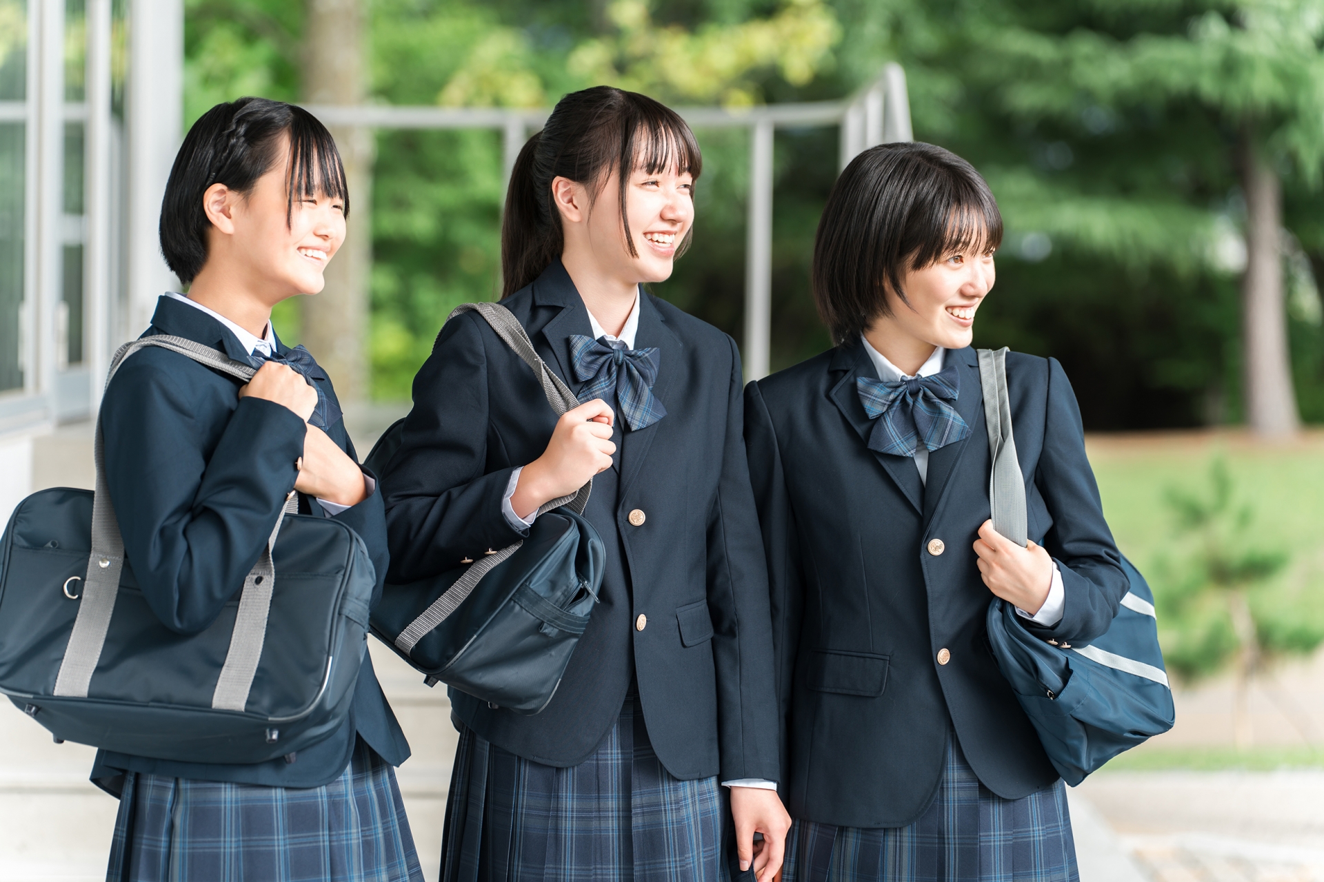 笑顔で校舎を歩く仲良しの女子学生(通学)