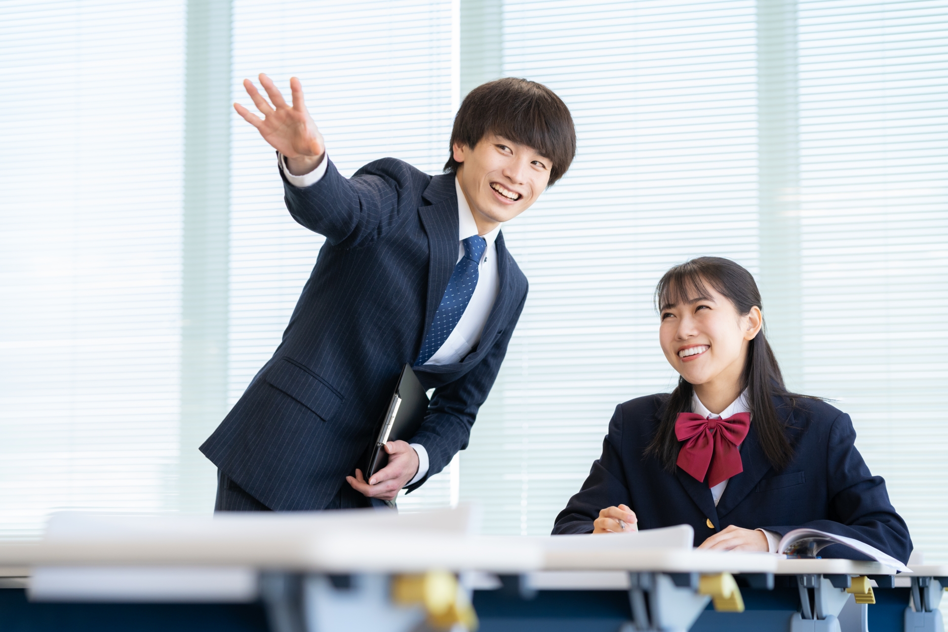 学校で勉強を教える先生と女子高生