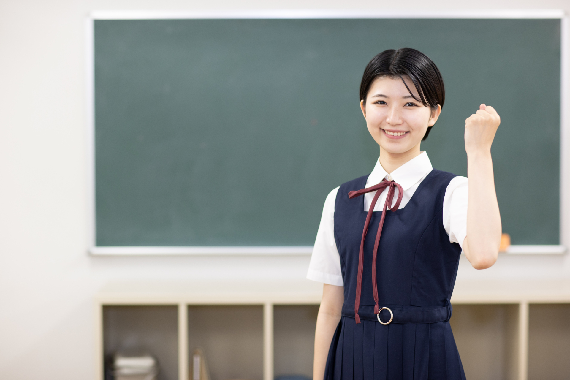 教室で笑顔で頑張りますのポーズをする高校生（左手）