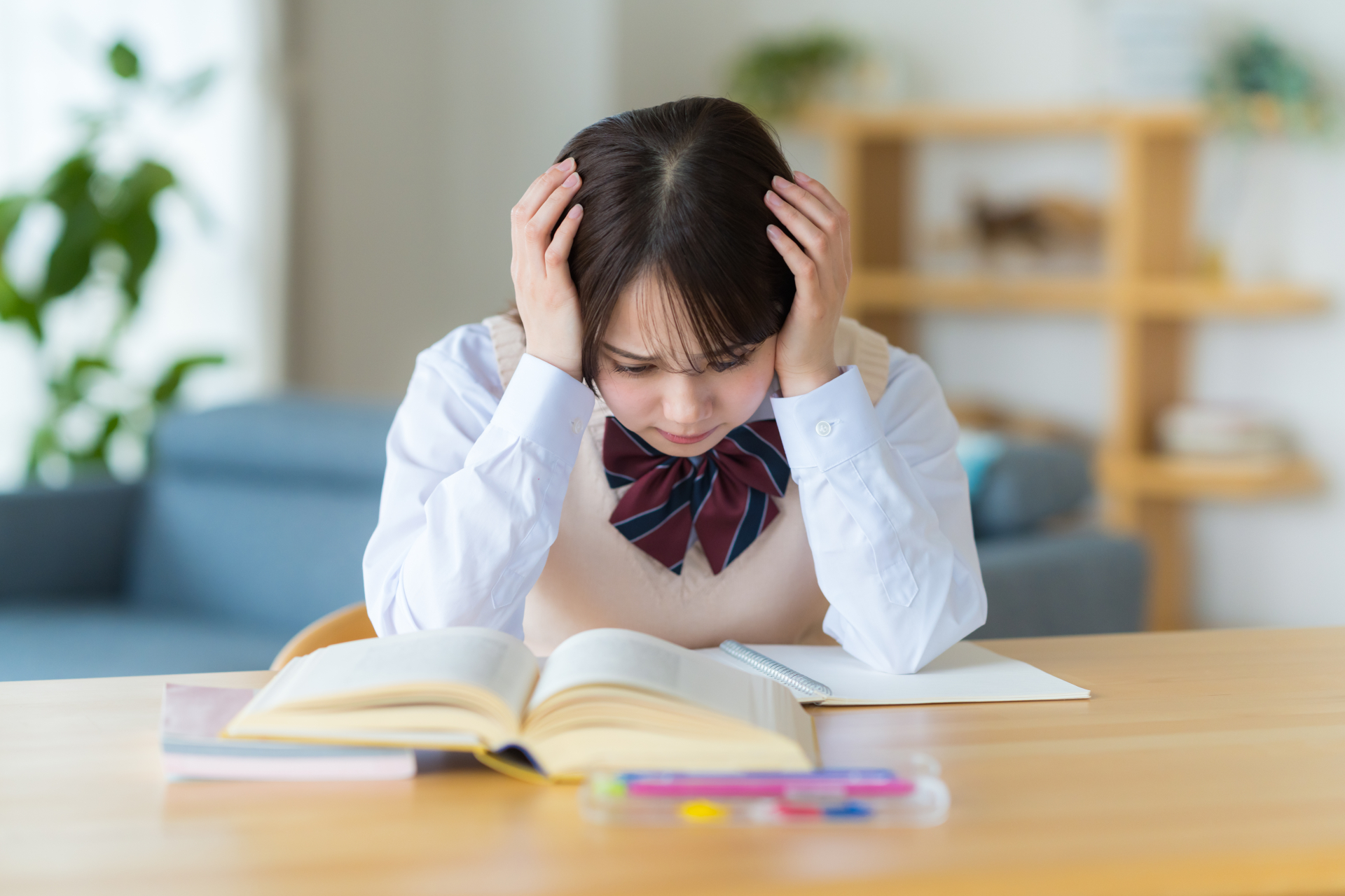 自宅で勉強中に悩む女子高生