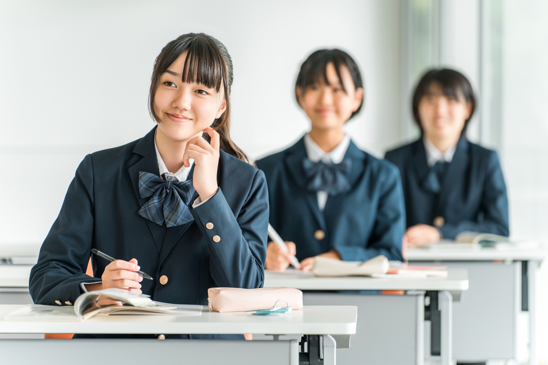 学校の教室で授業を聞く中学生・高校生