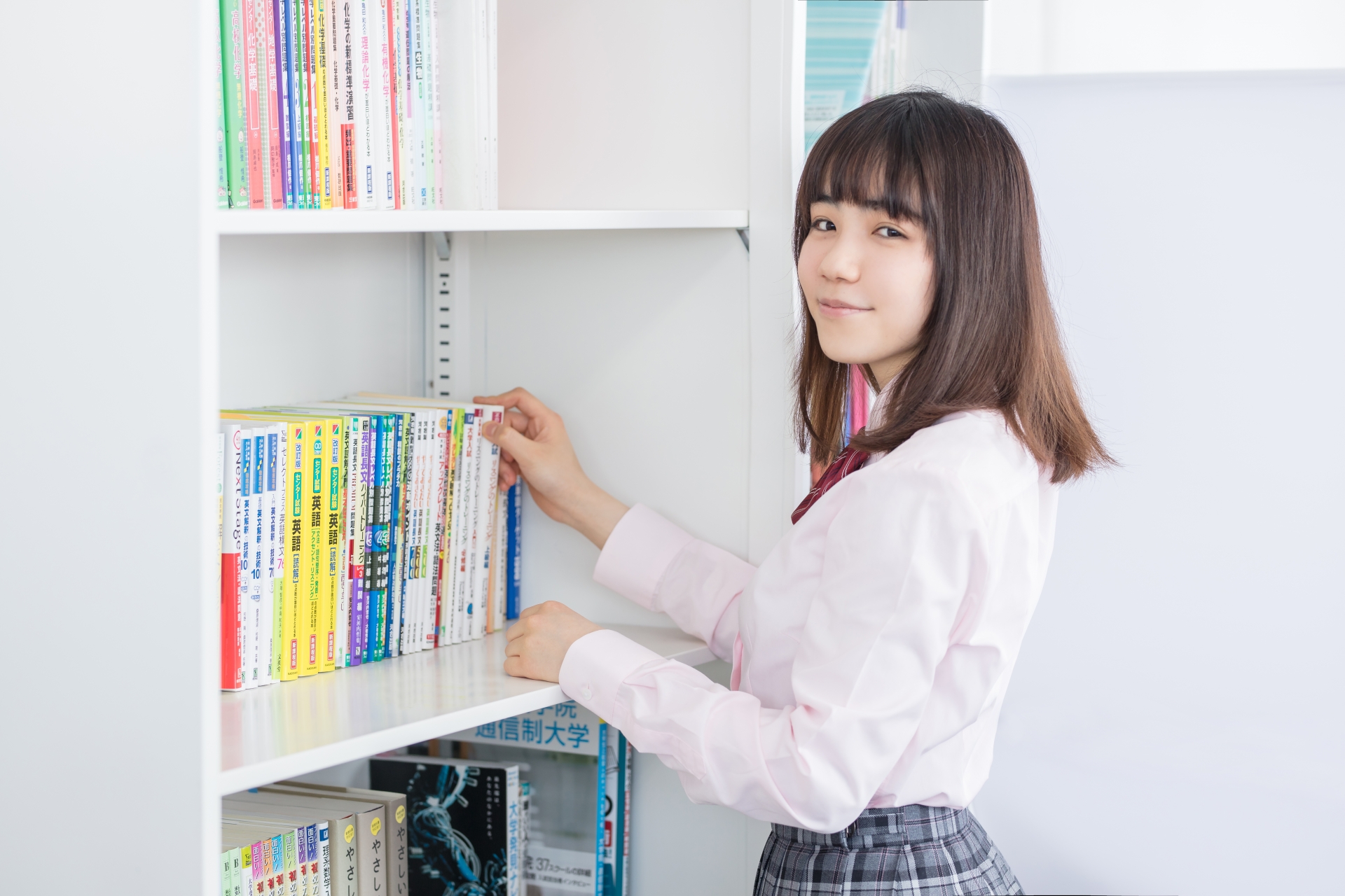参考書を手に取る女子高生