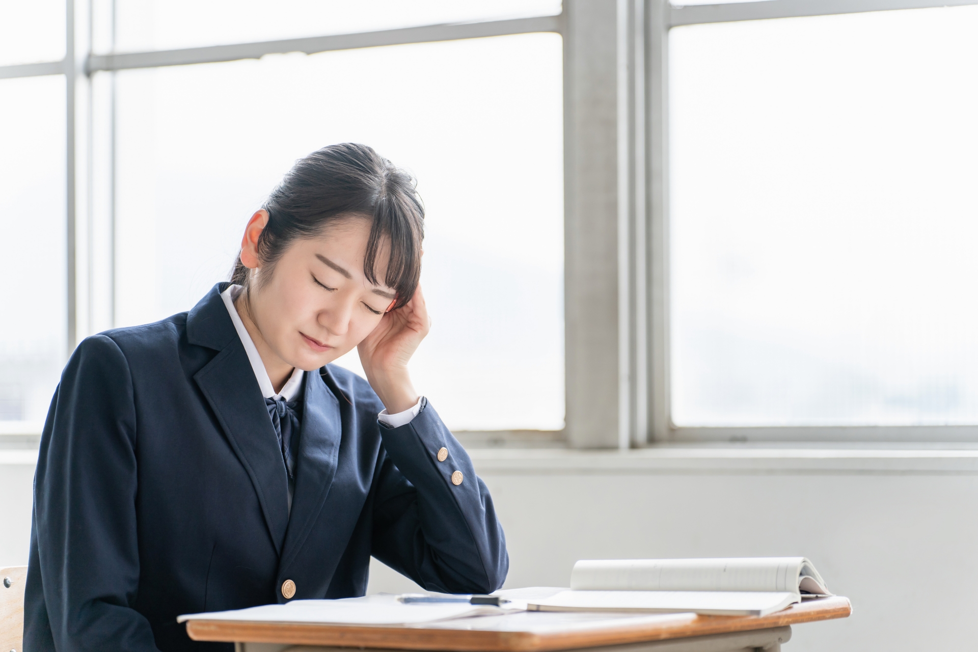 学校の教室で悩む・困る女子高校生（頭痛）