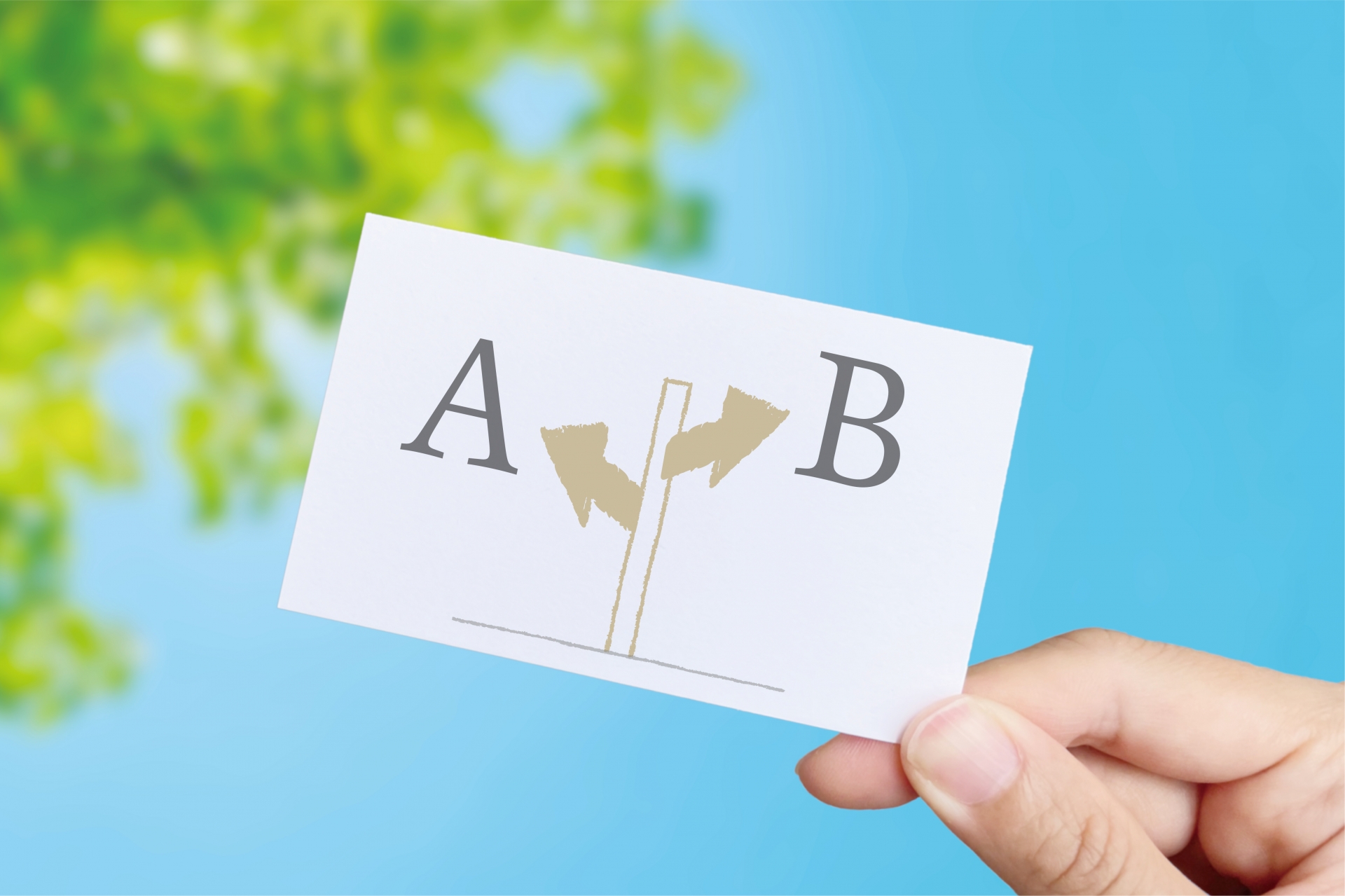 青空と葉を背景に「分かれ道」のマーク