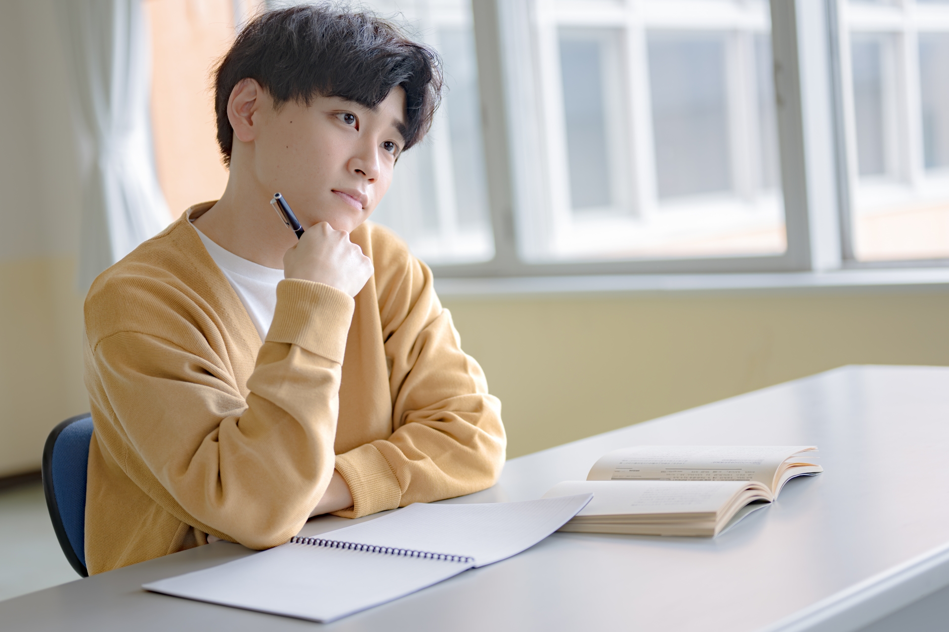 悩む勉強中の私服男性