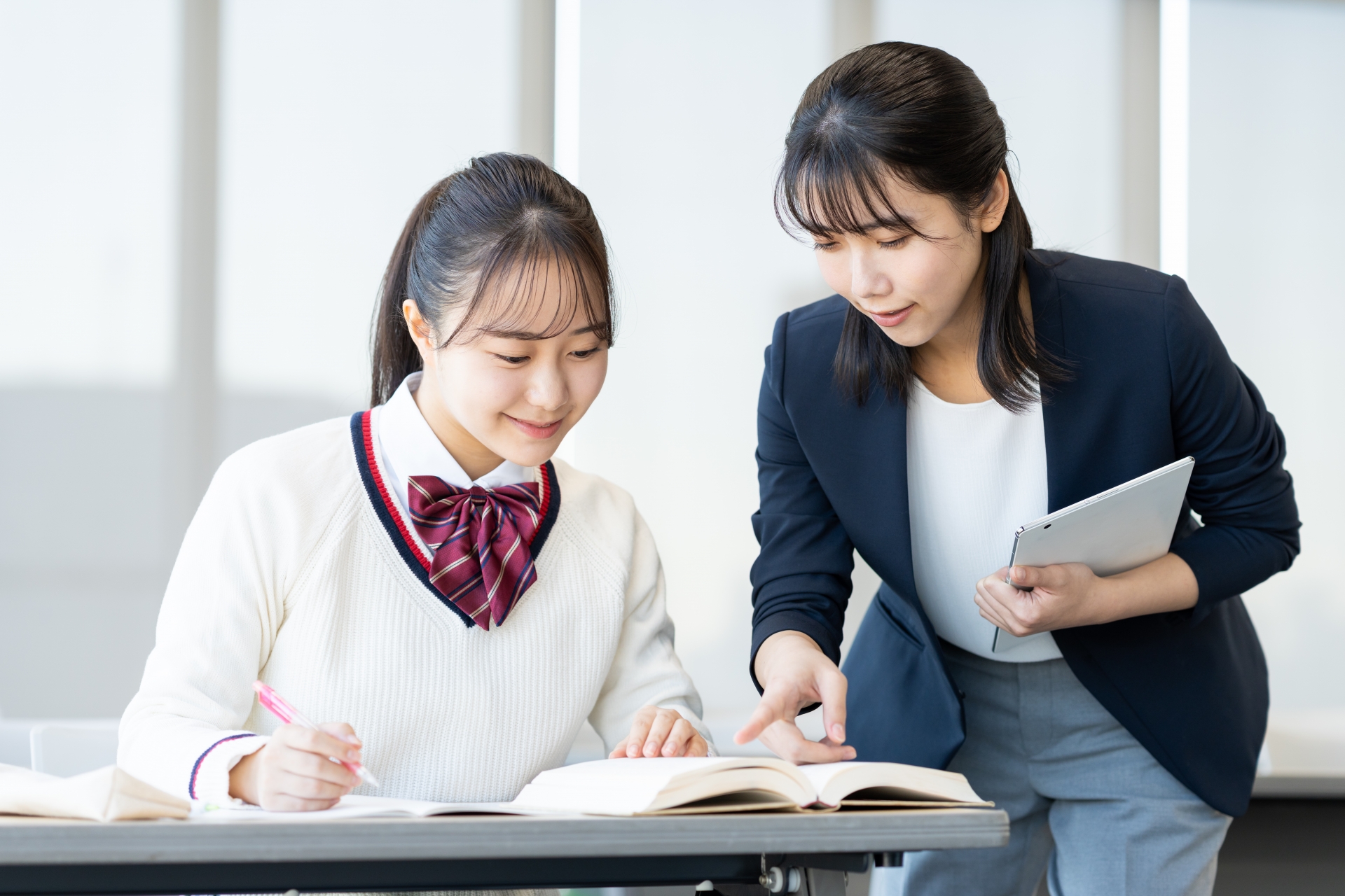 塾で勉強する高校生と先生